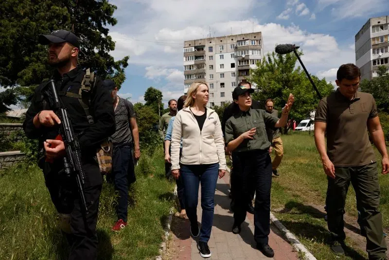 السفيرة الأمريكية لدى أوكرانيا، بريجيت برينك، تتحدث مع مسؤولين أوكرانيين أثناء زيارة ميدانية في منطقة متضررة من الحرب.