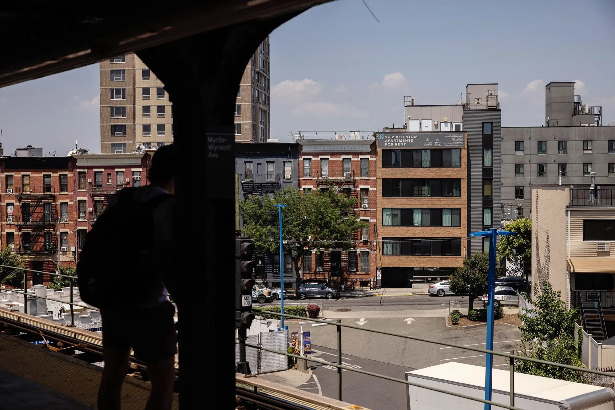 مشهد حضري يظهر مباني سكنية متنوعة في مدينة أمريكية، مع تركيز على الإيجارات والتحديات المالية للمستأجرين.