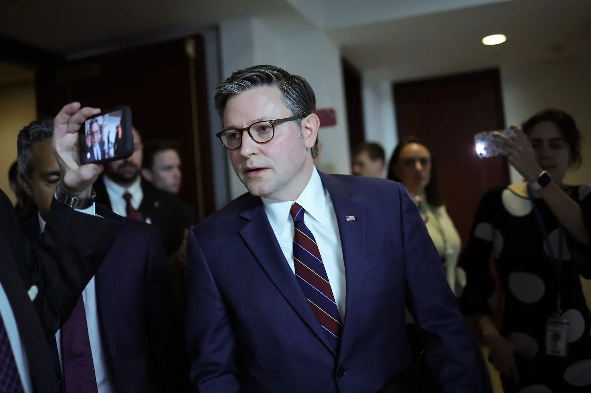 رئيس مجلس النواب مايك جونسون يتحدث مع أعضاء الكونغرس، محاطًا بمساعدين وصحفيين، أثناء مناقشة التشريعات الجمهورية المقبلة.