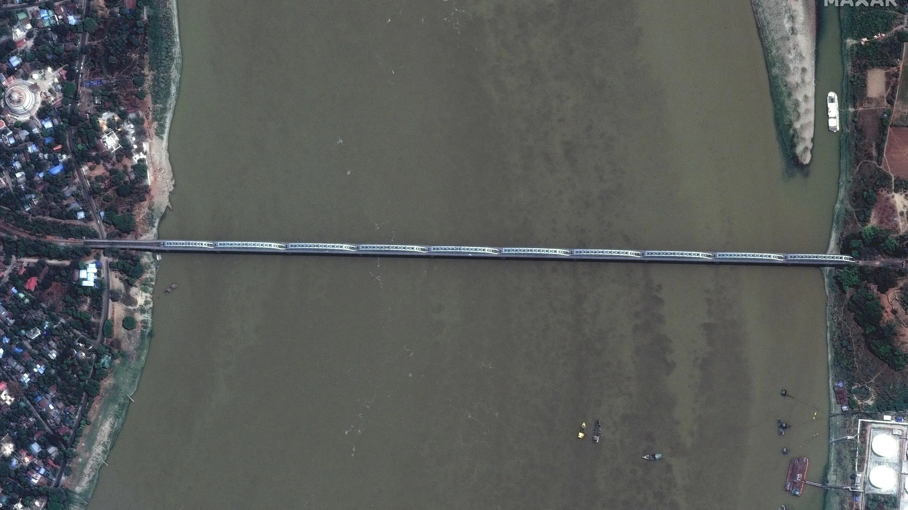 صورة جوية لجسر يمتد عبر نهر، مع مناظر للمنازل والمزارع المحيطة، تم تصويرها بعد الزلزال المدمر في ميانمار.