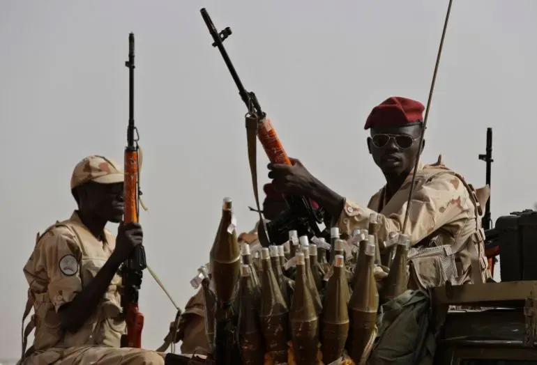 جنود يرتدون زي قوات الدعم السريع السودانية، يحملون أسلحة في مركبة عسكرية، تعبيراً عن التوترات المستمرة في الصراع في شمال كردفان.