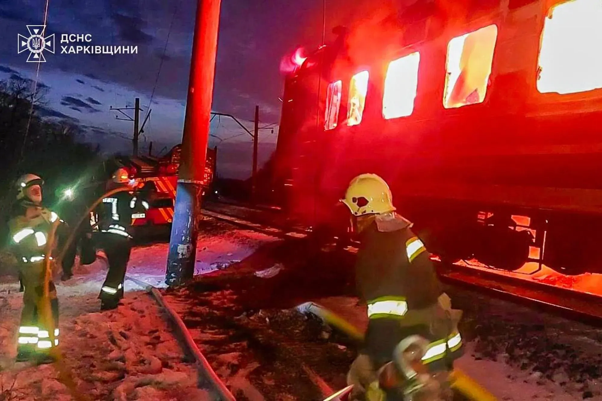 رجال الإطفاء يعملون على إخماد حريق في قطار ركاب محترق بعد هجوم بطائرة مسيرة في منطقة خاركيف، وسط ظروف جوية صعبة.