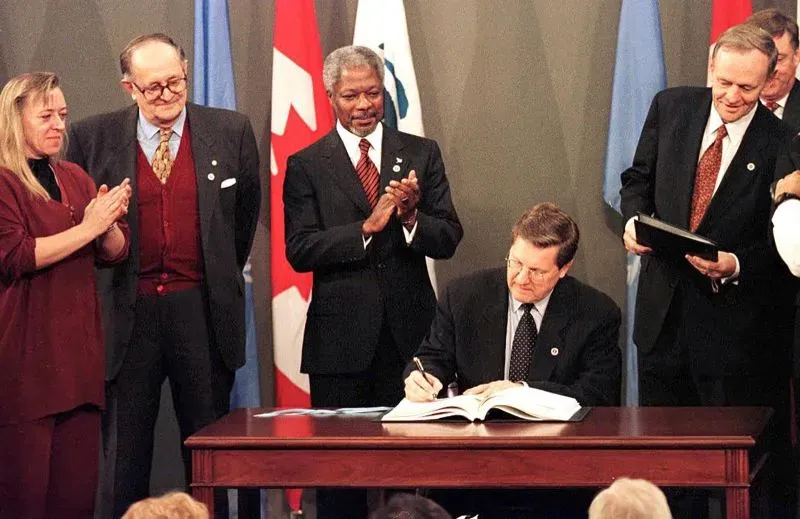 توقيع معاهدة أوتاوا لحظر الألغام الأرضية، مع وجود شخصيات بارزة، مما يعكس جهود نزع السلاح العالمي.