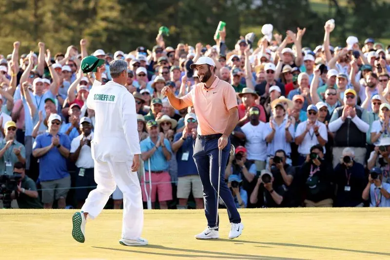 شافلر يحتفل مع مشجعيه بعد تحقيق الفوز. يظهر اللاعب مرتديًا قميصًا برتقاليًا بينما يحمل شخص آخر قبعة. الخلفية مليئة بالمشجعين المتحمسين.