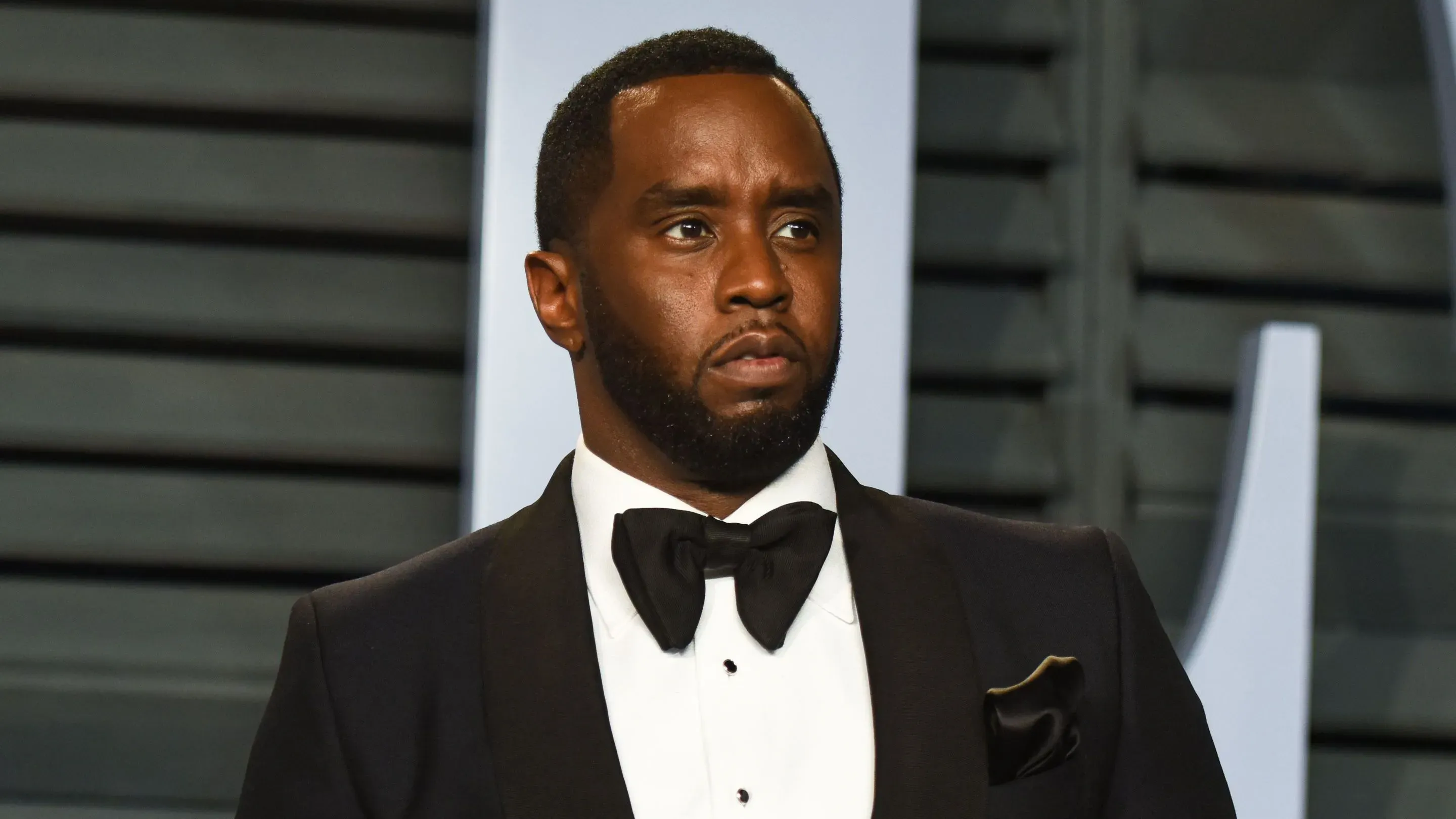 شون "ديدي" كومبس يرتدي بدلة رسمية، يظهر تعبيره الجاد قبيل بدء محاكمته بتهمة الاتجار بالجنس في مانهاتن.