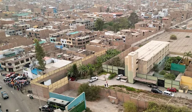 صورة جوية لمدينة ليما في بيرو، تظهر المباني الكثيفة والشوارع المزدحمة، مما يعكس الوضع السياسي المتوتر في البلاد.