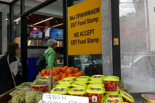 لافتة تشير إلى قبول طوابع الغذاء EBT في متجر، مع عرض للفاكهة والخضروات الطازجة، مما يعكس تأثير تغييرات قانون المساعدة الغذائية.