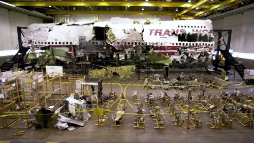 حطام طائرة TWA 800 المعاد بناؤه، يظهر الأجزاء المدمرة في مركز التحقيق، مع وجود أدوات استعادة حوله، بعد الانفجار المأساوي.
