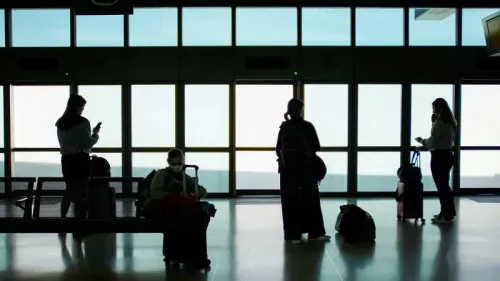 مسافرون ينتظرون في مطار، حيث تظهر silhouettes لأشخاص يحملون حقائبهم ويتواصلون عبر الهواتف، مع خلفية نوافذ مضاءة.