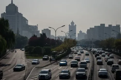 شوارع بكين مكتظة بالسيارات الكهربائية التي تحمل لوحات خضراء، تعكس تحول المدينة نحو التنقل المستدام والهدوء.