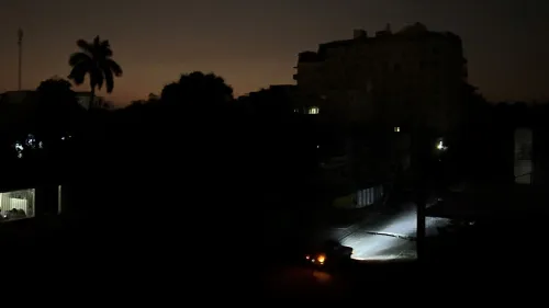 تظهر الصورة شوارع هافانا المظلمة بعد انقطاع التيار الكهربائي، حيث يستخدم الناس المشاعل للتنقل في الظلام.
