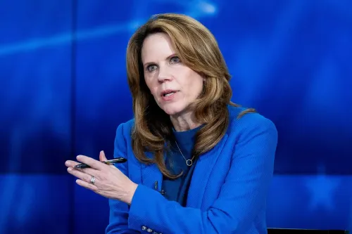 امرأة ترتدي سترة زرقاء، تتحدث بجدية أثناء مناقشة سياسية، تعكس نتائج الانتخابات الأخيرة في جورجيا وويسكونسن.