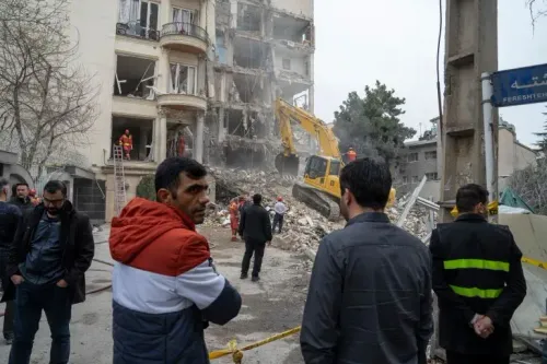 مشهد لرجال يتابعون عملية إزالة الأنقاض من مبنى مدمر في طهران، حيث تتواصل تداعيات الهجمات العسكرية في المنطقة.