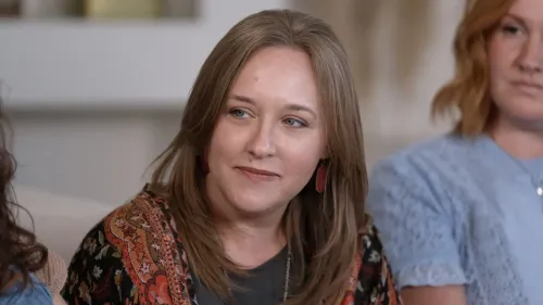 تظهر كاتي، امرأة ذات شعر بني طويل، تتحدث بجدية عن تجربتها مع القومية المسيحية والأصولية، محاطة بأخريات في جلسة نقاش.