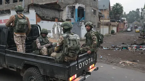 جنود من القوات المسلحة يقفون في شاحنة عسكرية في غوما، مع خلفية تعكس التوترات الأمنية والقتال المتواصل في المنطقة.