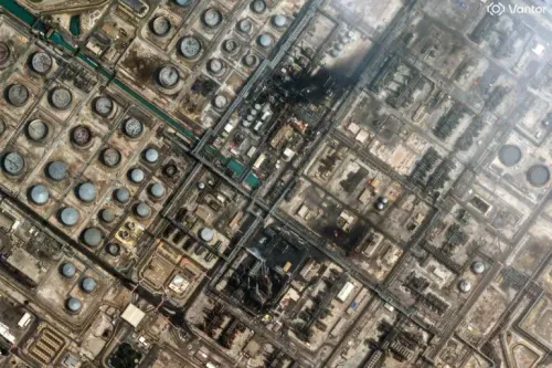 صورة جوية لموقع صناعي يحتوي على خزانات نفطية ومنشآت، مع وجود آثار حريق في أحد المناطق، تعكس تصاعد التوترات في الشرق الأوسط.