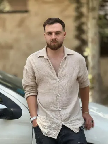 شاب إيراني يُدعى عرفان سلطاني، يقف بجوار سيارة، وسط مخاوف من إعدامه بسبب مشاركته في الاحتجاجات ضد الحكومة.