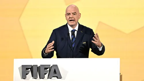 جياني إنفانتينو، رئيس الفيفا، يتحدث في مؤتمر صحفي حول استضافة كأس العالم للسيدات 2023 و2031، مع خلفية صفراء.