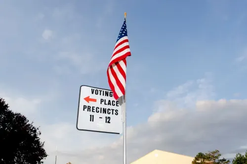 علامة تشير إلى مكان الاقتراع مع العلم الأمريكي، تبرز أهمية الانتخابات التمهيدية في تحديد مرشحي الحزب الديمقراطي لعام 2028.