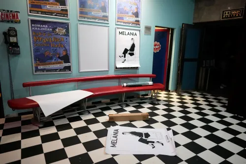 صورة لقاعة سينما تحتوي على مقاعد حمراء وملصق لفيلم "ميلانيا" على الحائط، مما يعكس أجواء عرض الفيلم الوثائقي.
