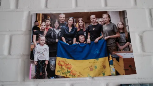 مجموعة من الأطفال والمراهقين الأوكرانيين يحملون علم أوكرانيا، مع وجود متطوعين من منظمة "أنقذوا أوكرانيا" في الخلفية، بعد عودتهم من روسيا.