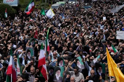 حشد كبير من المتظاهرين في إيران يرفعون الأعلام واللافتات، مع تظاهرهم بالاحتجاج بعد الصراع مع إسرائيل والولايات المتحدة.