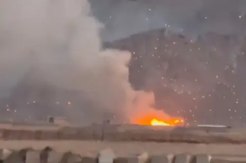 تصاعد الدخان والنيران في موقع هجوم جوي، مع تأثيرات واضحة على المنطقة المحيطة، مما يعكس تصاعد التوترات العسكرية بين إيران وإسرائيل.