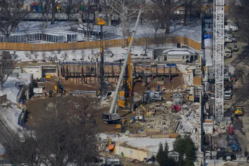 مشهد لموقع بناء قاعة احتفالات جديدة بقيمة 400 مليون دولار بالقرب من البيت الأبيض، يظهر المعدات والعمال في موقع العمل.