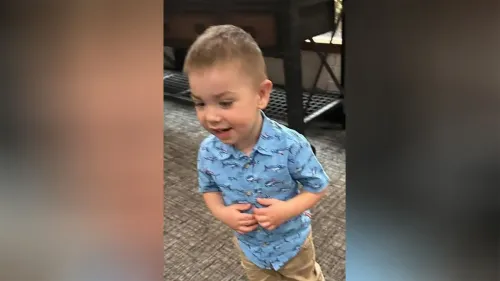 صبي صغير يرتدي قميصًا أزرق مزخرفًا بأسماك، يبدو سعيدًا وهو يلعب، في سياق البحث عن الصبي المفقود في أوريغون.