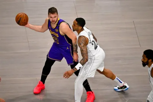 لوكا دونشيتش، لاعب لوس أنجلوس ليكرز، يت dribble الكرة بينما يتصدى له لاعب من فريق دالاس مافريكس، في مباراة مثيرة ضمن الدوري الأمريكي للمحترفين.