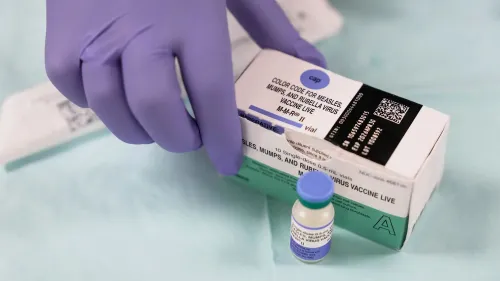 عبوة لقاح الحصبة والنكاف والحصبة الألمانية (MMR) مع زجاجة صغيرة بجانبها، تشير إلى أهمية التطعيم في مواجهة تفشي الحصبة.