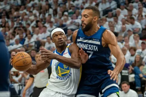 لاعب من فريق جولدن ستيت ووريورز يحاول التمرير بينما يتصدى له لاعب من مينيسوتا تيمبروولفز في مباراة نصف نهائي المؤتمر الغربي.