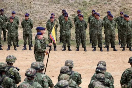 جنود يرتدون زيًا عسكريًا في صفوف أثناء تدريب في كولومبيا، مما يبرز مشكلة تجنيد الأطفال في النزاعات المسلحة.