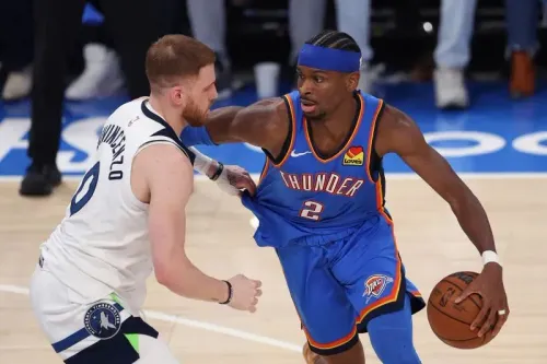 لاعب فريق أوكلاهوما سيتي ثاندر يت dribble الكرة بينما يواجه مدافعاً من مينيسوتا تمبروولفز في مباراة حاسمة ضمن نهائيات المؤتمر الغربي.