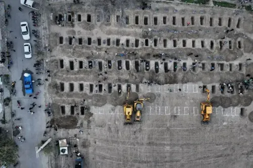 مقبرة جماعية في إيران تحتوي على صفوف من القبور، مع وجود جرافات وعمال يدفنون الضحايا، مما يعكس آثار الحرب.