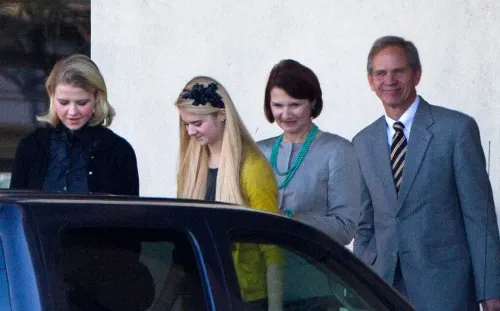 إليزابيث سمارت، الناجية من الاختطاف، مع عائلتها، يظهرون معًا خارج سيارة، يعكسون دعمهم ومساندتهم لها بعد تجربتها الصعبة.