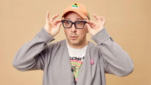ستيف بيرنز، مقدم برنامج "Blue's Clues"، يرتدي نظارات وقبعة، ويظهر تعبيرًا فضوليًا أثناء الترويج لبودكاسته الجديد "على قيد الحياة".