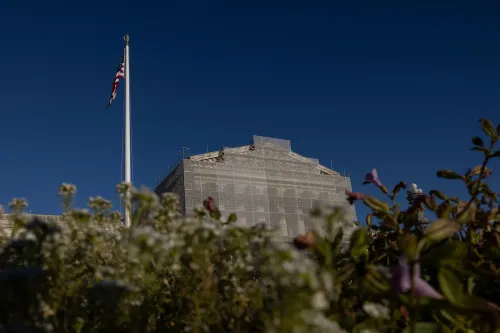 مبنى المحكمة العليا الأمريكية مع العلم الأمريكي في المقدمة، يظهر في إطار جميل مع أزهار في الحديقة، مما يعكس أهمية القضايا القانونية المتعلقة بمبيد "راوندأب".