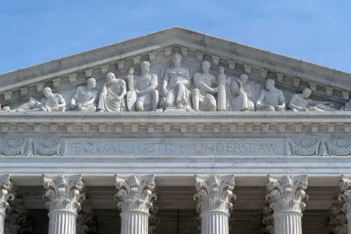 واجهة المحكمة العليا الأمريكية، تظهر تماثيل تمثل العدالة والمساواة تحت القانون، مع نقش "العدالة المتساوية تحت القانون".