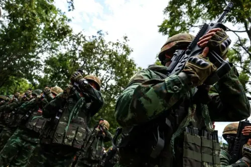 جنود تايلانديون يرتدون زيًا عسكريًا ويحملون أسلحة في غابة، في ظل تصاعد التوترات الحدودية مع كمبوديا.