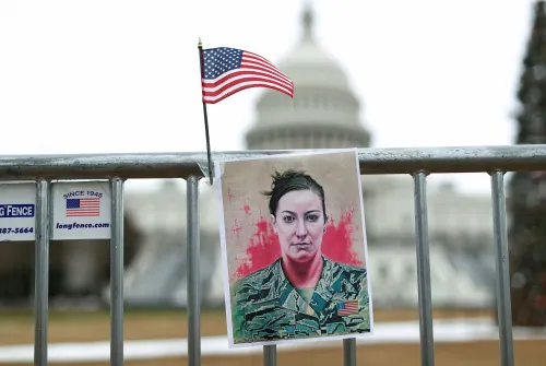 صورة لعلم أمريكي صغير ومؤسسة تحمل صورة آشلي بابيت، المحاربة السابقة في سلاح الجو، أمام مبنى الكابيتول، تذكير بأحداث 6 يناير 2021.