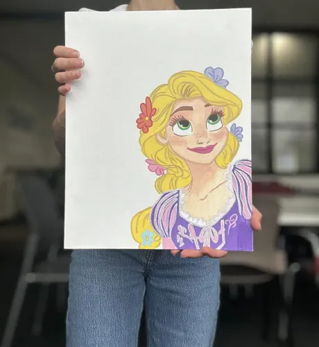 رسم ملون لشخصية خيالية ذات شعر أشقر وعيون كبيرة، تحمل زهورًا في شعرها، تعكس الأمل والبراءة في سياق قضايا الهجرة.