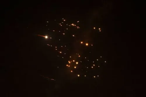 شظايا صاروخية تتساقط في السماء ليلاً، مما يعكس الأثر المدمر للهجمات الإيرانية على المناطق الفلسطينية، حيث قُتلت ثلاث نساء في صالون.