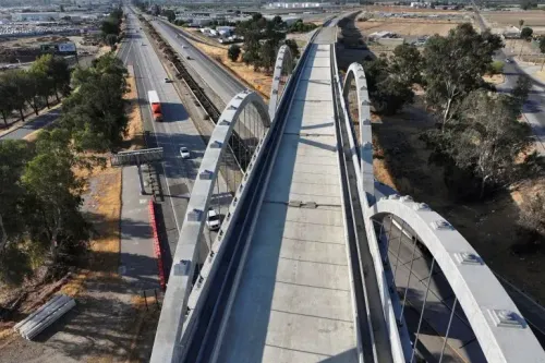 صورة لجسر معلق يعلو طريق سريع في كاليفورنيا، حيث يظهر مشروع السكك الحديدية الفائق السرعة المتعثر الذي أوقفه ترامب.