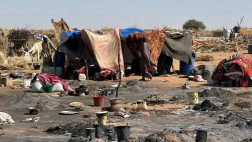 مخيم للنازحين في الفاشر، يظهر خيامًا متهالكة وأوانٍ مقلوبة، مما يعكس الظروف القاسية التي يواجهها السكان بسبب النزاع.