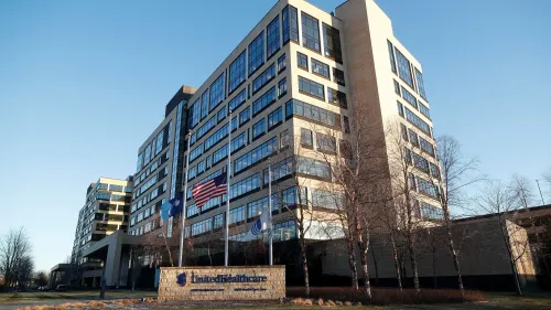 مبنى شركة UnitedHealthcare يظهر في الصورة مع أعلام الولايات المتحدة، مما يعكس التحديات التي تواجهها الشركة في قطاع الرعاية الصحية.