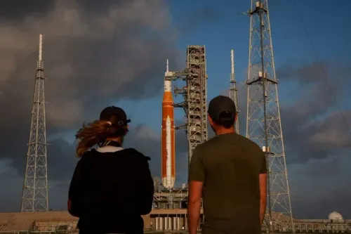 مركبة أرتميس 2 جاهزة للإطلاق من مركز كينيدي للفضاء، حيث يراقب شخصان الإعدادات النهائية قبل المهمة القمرية المأهولة.