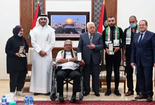 تجمع عدد من الأشخاص في احتفال رسمي، حيث يتوسطهم الرئيس الفلسطيني محمود عباس، لتكريم الصحفيين الفلسطينيين.