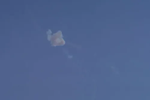 سحابة دُخانية تتصاعد في السماء الزرقاء، تشير إلى تصعيد عسكري في الصراع بين إيران والولايات المتحدة وإسرائيل.