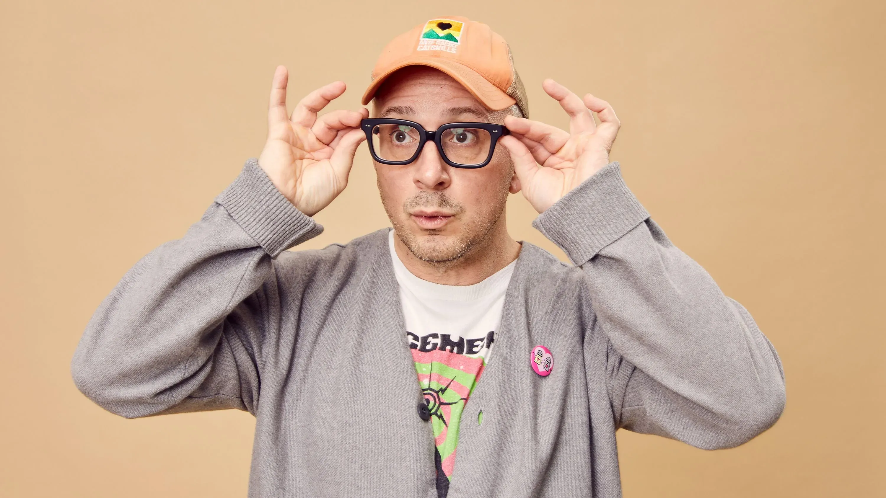 ستيف بيرنز، مقدم برنامج "Blue's Clues"، يرتدي نظارات وقبعة، ويظهر تعبيرًا فضوليًا أثناء الترويج لبودكاسته الجديد "على قيد الحياة".